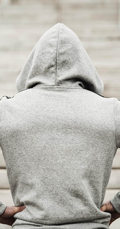Rear view of hooded sports man about to run upstairs